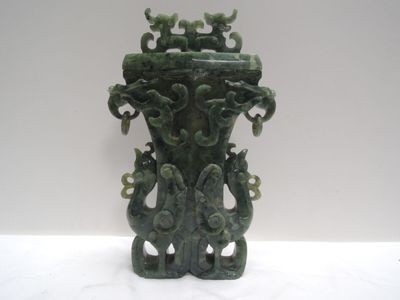 un vase vert posé sur une table blanche