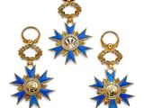 un lot de trois breloques en forme d'étoile en or et émail bleu