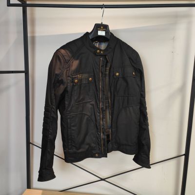 une veste en cuir suspendue à un portant dans un magasin de vêtements