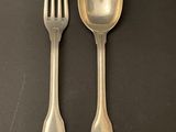 two forks and a spoon on a black surface