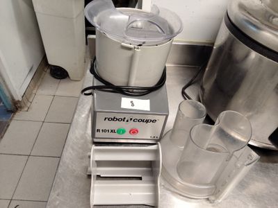 un mixeur posé par terre à côté d'un verre d'eau