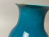 a blue vase sitting on a table with a white background