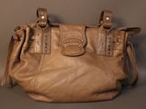 brown leather handbag sitting on a grey surface with a brown background