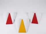 trois triangles rouges et jaunes posés sur une surface blanche