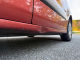 a red car that is parked on the side of the road