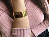 a woman that is wearing a pink sweater and a gold bracelet