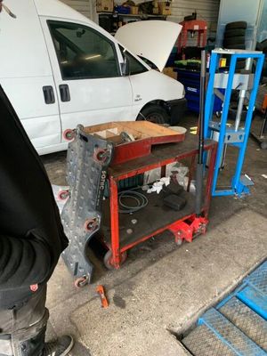 une camionnette blanche garée dans un garage, à côté d'un établi