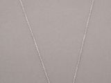 a silver necklace with a white pearl on a silver chain