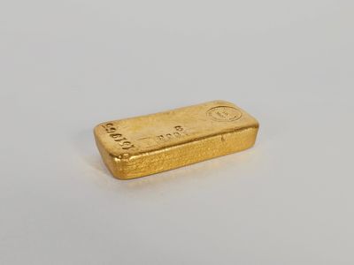 une barre d'or posée sur une surface blanche