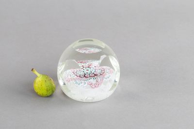 une petite figurine en verre posée à côté d'une autre figurine sur une table