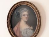 portrait d'une femme en robe bleue, avec une fleur bleue dans les cheveux