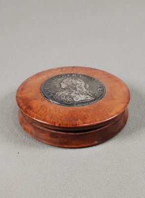two small wooden boxes with a silver coin on top of them