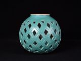un vase vert orné d'un motif en treillis