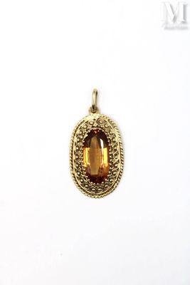 a close up of a gold pendant with a faceted citrine stone