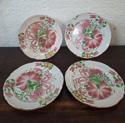 three plates with floral designs on them sitting on a table