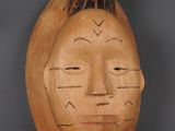 une image d'un masque en bois sur fond noir