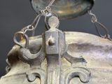 a close up of a large metal object hanging from a chain