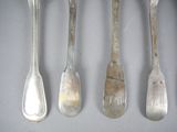 five silver spoons and two silver spoons hanging on a wall