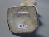 a white vase with a label on it sitting on a table