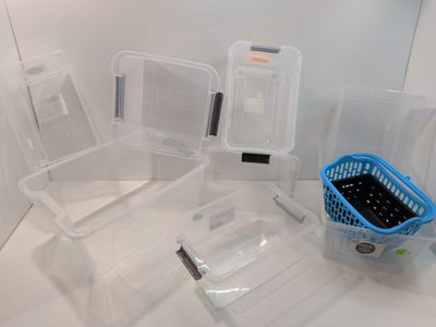 de nombreux récipients en plastique posés sur un plan de travail dans une salle de bains