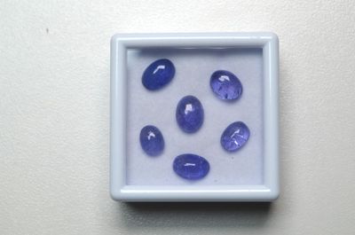 une photo montrant des pierres bleues dans une boîte blanche