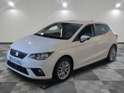 the white car is parked on a checkered floor in a room