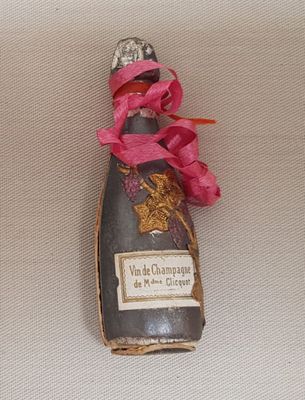 a bottle of wine with a pink ribbon tied to it