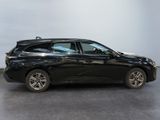 the black car is parked in the room on the concrete floor