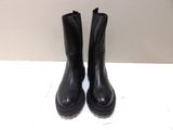 black leather boots with rubber soles on a white surface