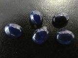 un gros plan sur un groupe de pierres bleues posées sur une surface noire