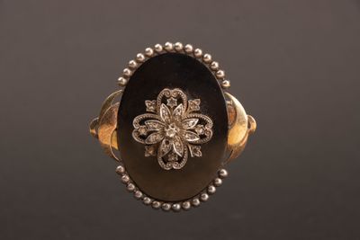 Gros plan sur une bague en or ornée d'une fleur