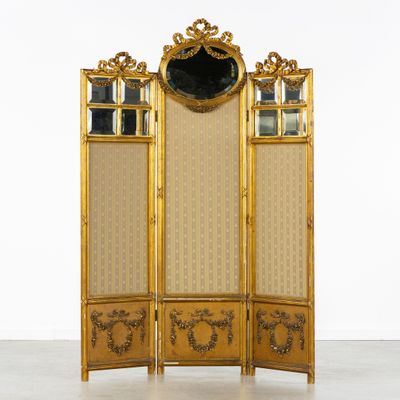 un écran doré surmonté d'un miroir