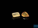 a pair of yellow sapphires on a black surface
