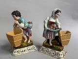 deux figurines représentant une femme et un enfant assis dans un panier