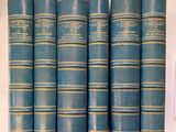 six livres bleus sont alignés sur une étagère dans une pièce