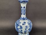 a blue and white vase with a floral design on it