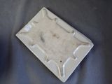 a white ashtray with a cigarette in it on a table