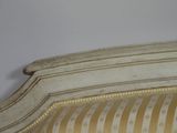 a close up of a bed with a striped headboard