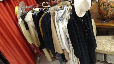 beaucoup de vêtements suspendus à une étagère dans une pièce
