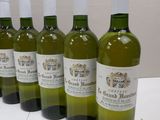 six bottles of wine are lined up on a table