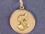 un collier plaqué or sur lequel figure l'image d'une femme