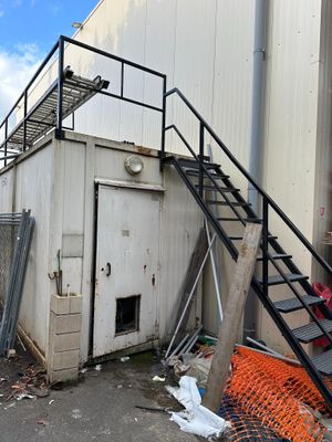 a pile of trash outside of a building next to a staircase