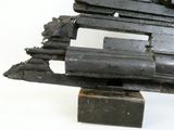 une petite maquette de pistolet posée sur une surface blanche