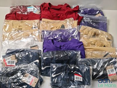 beaucoup de t-shirts de différentes couleurs posés sur une table blanche