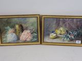 deux tableaux encadrés représentant des fruits et des fleurs posés sur une table
