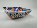 an image of a blue and orange bowl sitting on top of a white table