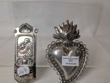 pair of silver plated heart shaped objects on display in a glass case