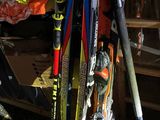many skis and ski poles that are stacked up