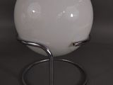 a white ball on a metal stand on a black surface