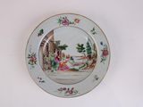 a plate with a painting on it hanging on a wall